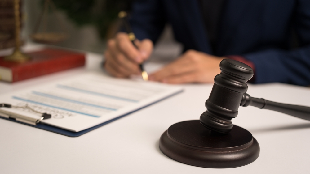 Criminal defense lawyer reviewing legal documents beside a courtroom gavel