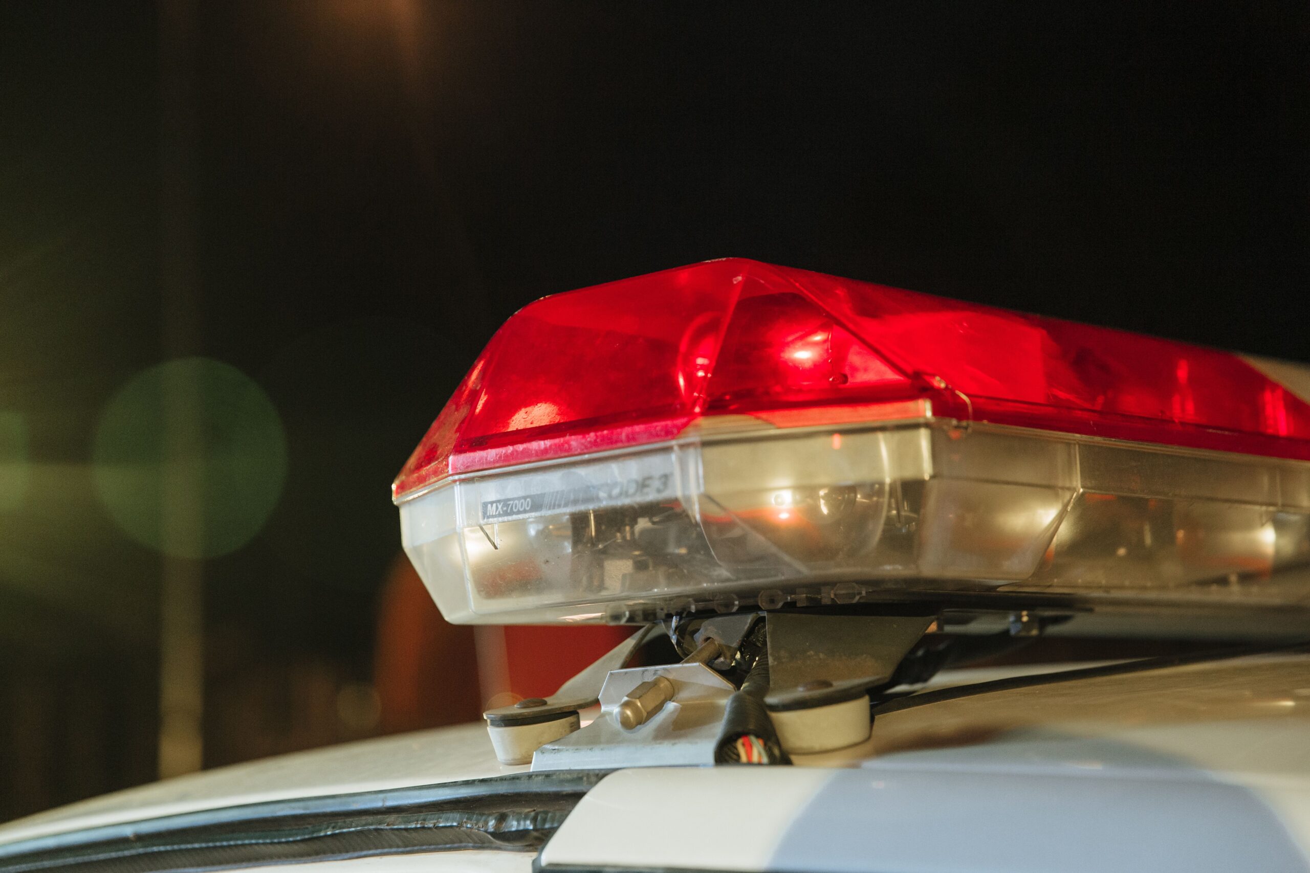 Red police light bar on a patrol car at night during a Houston summer weekend DWI stop