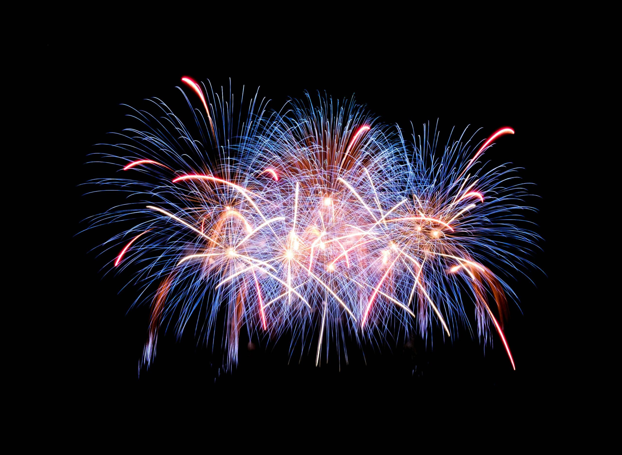 Red, white, and blue fireworks lighting up the night sky during a Fourth of July celebration in Houston
